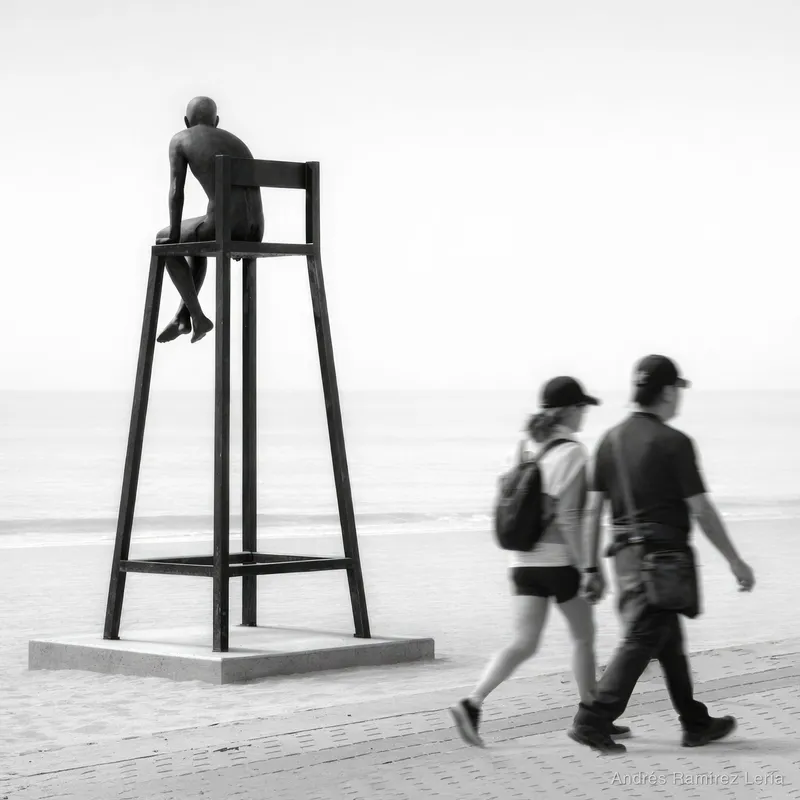 Cinco minutos parado en el paseo marítimo, esperando a que algo encajara sin forzarlo. La escultura del vigilante mirando al mar, la tarde tranquila y la gente pasando sin darse cuenta. En un momento 