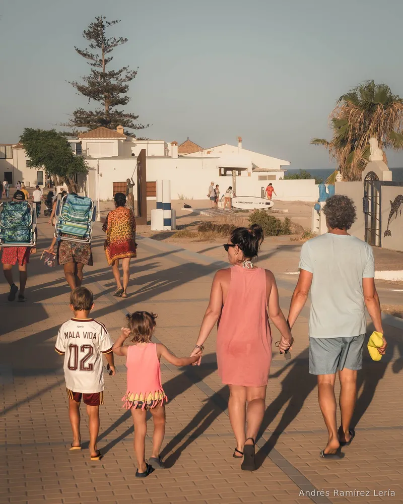 Volver de la playa al atardecer es una forma muy nuestra de medir el verano. No hace falta que pase nada extraordinario: una mano cogida, unas chanclas arrastrando arena, una silla plegable, una sombra larga sobre el paseo. A veces La Antilla se cuenta mejor en esos momentos en los que nadie posa y todo parece estar en su sitio.